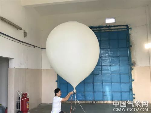 工作人员为准备施放的探空气球充气