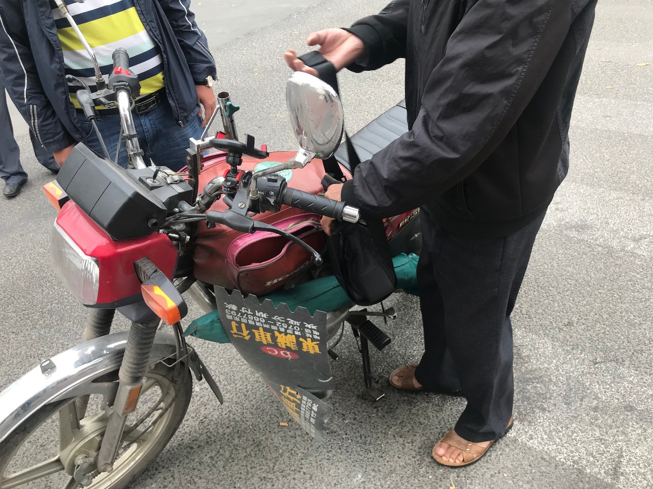 当行至人流密集的公园路时,看到一名骑外地车牌摩托车的男子,油箱上