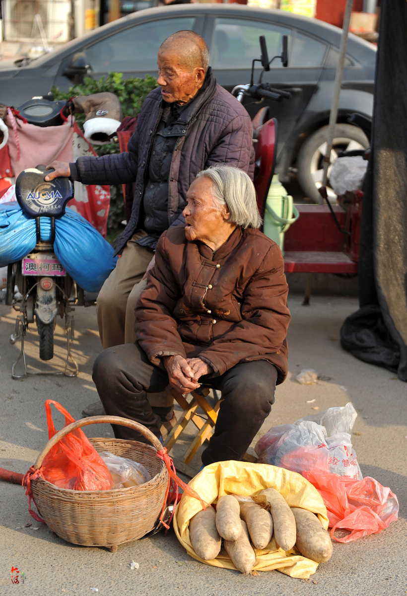 圖為夫妻倆與旁邊賣東西的小販聊天.