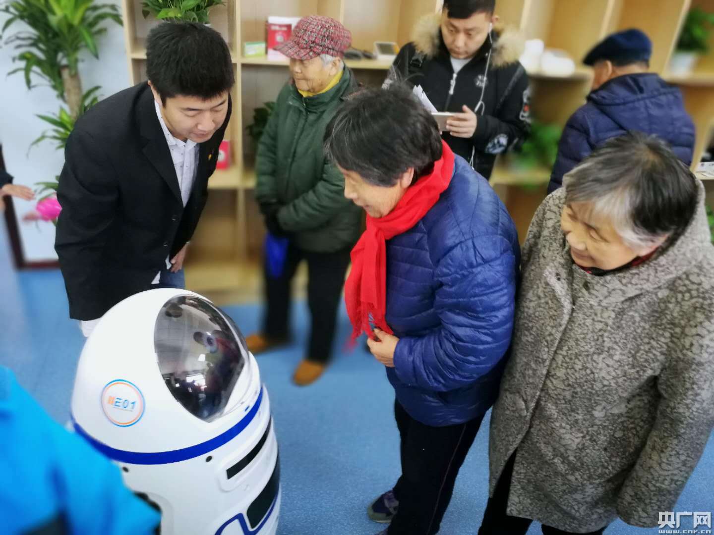 一名老人正在与智能陪伴型机器人互动