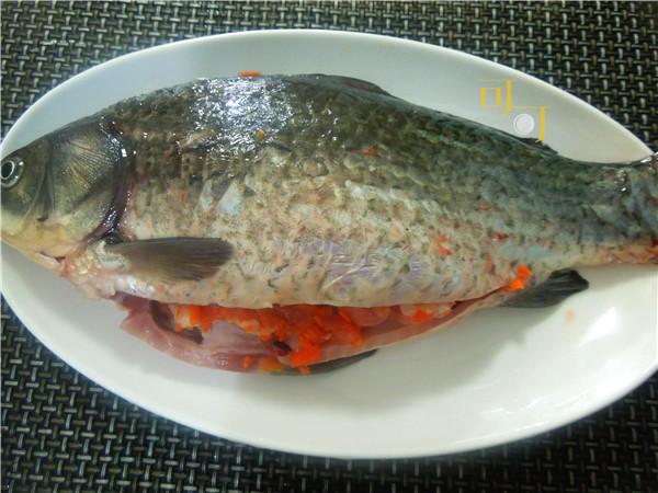 把醃製入味的肉末塞進魚肚裡熱鍋熱油,入鯽魚油煎一面煎成金黃,再翻面