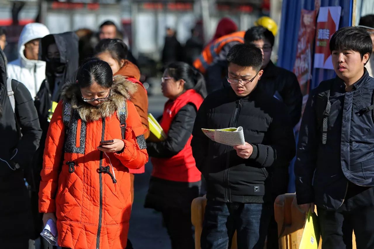 申论考试前,考生们在考场外抓紧复习 摄影|彭子洋