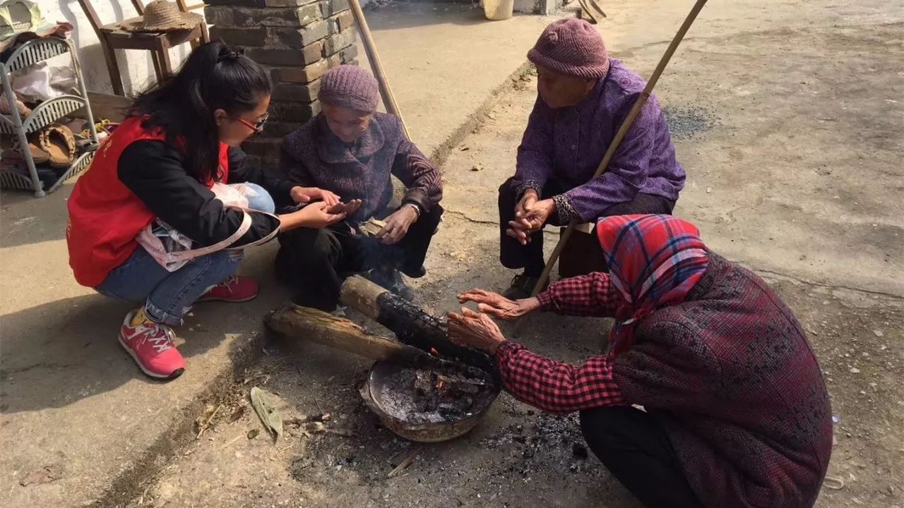 調研人員和村民在村裡烤火取暖,和村中老人親切聊天