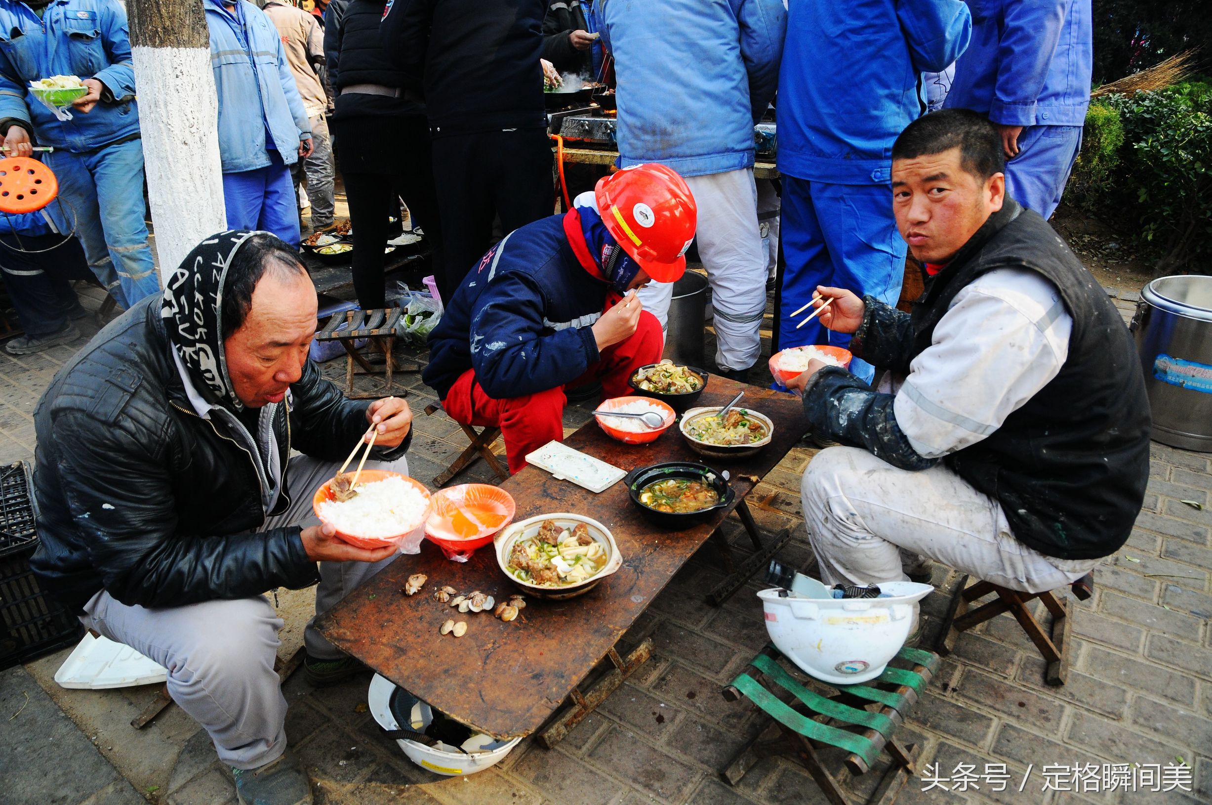 图为:三名师傅在吃饭午餐盒饭.