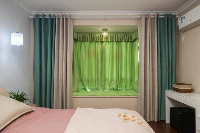 主卧带的小飘窗,飘窗窗帘是绿色装饰