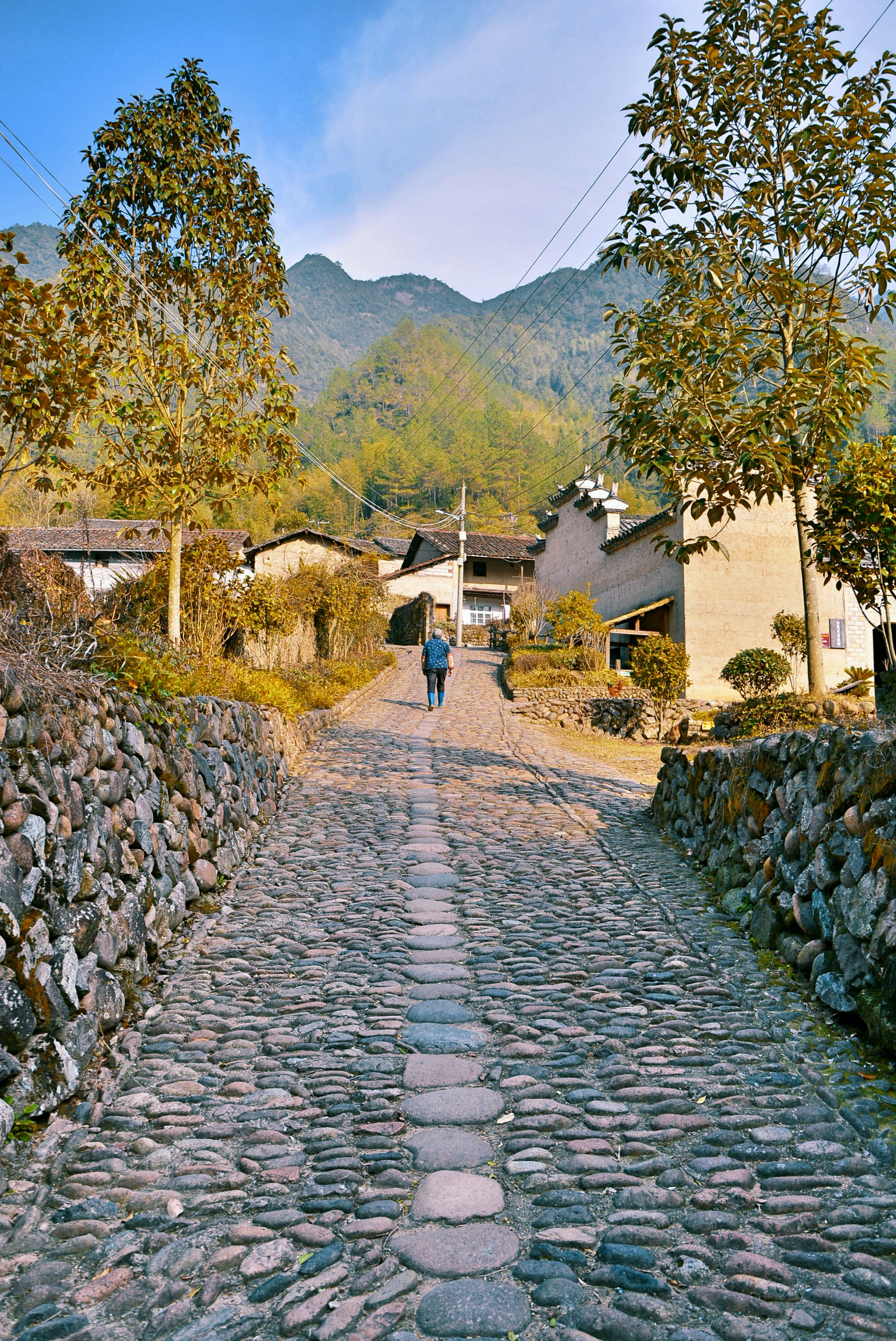 周围高山耸立,村前孤峰独峙,江水清流.