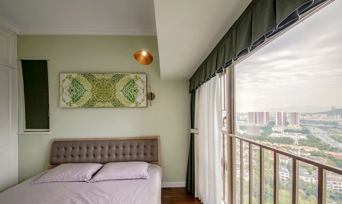 灰绿色作为整个卧室墙面的背景色,花卉图案的挂画穿插其中,墨绿的窗帘