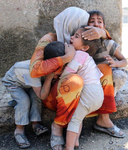 孩子被炮火吓的不知所措,母亲将他们紧紧的抱在怀里,保护着他们