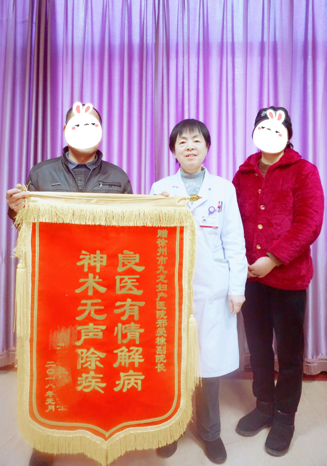 患者张女士携家人捧着印有"良医有情解病,神术无声除疾"的鎏金锦旗,送