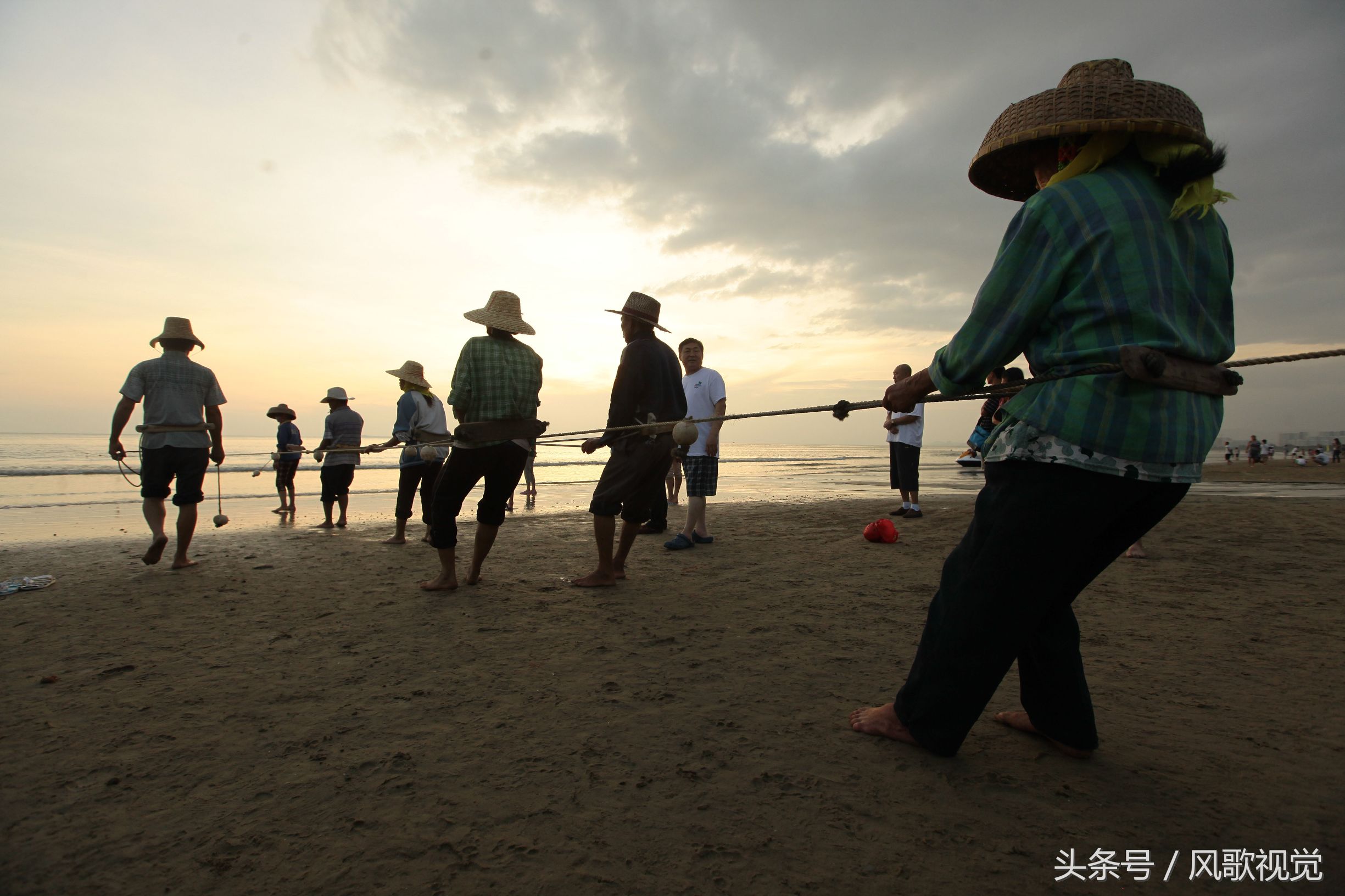 三亞灣的少數民族漁民拉網捕魚,傳統作業在夕陽餘暉中成美景