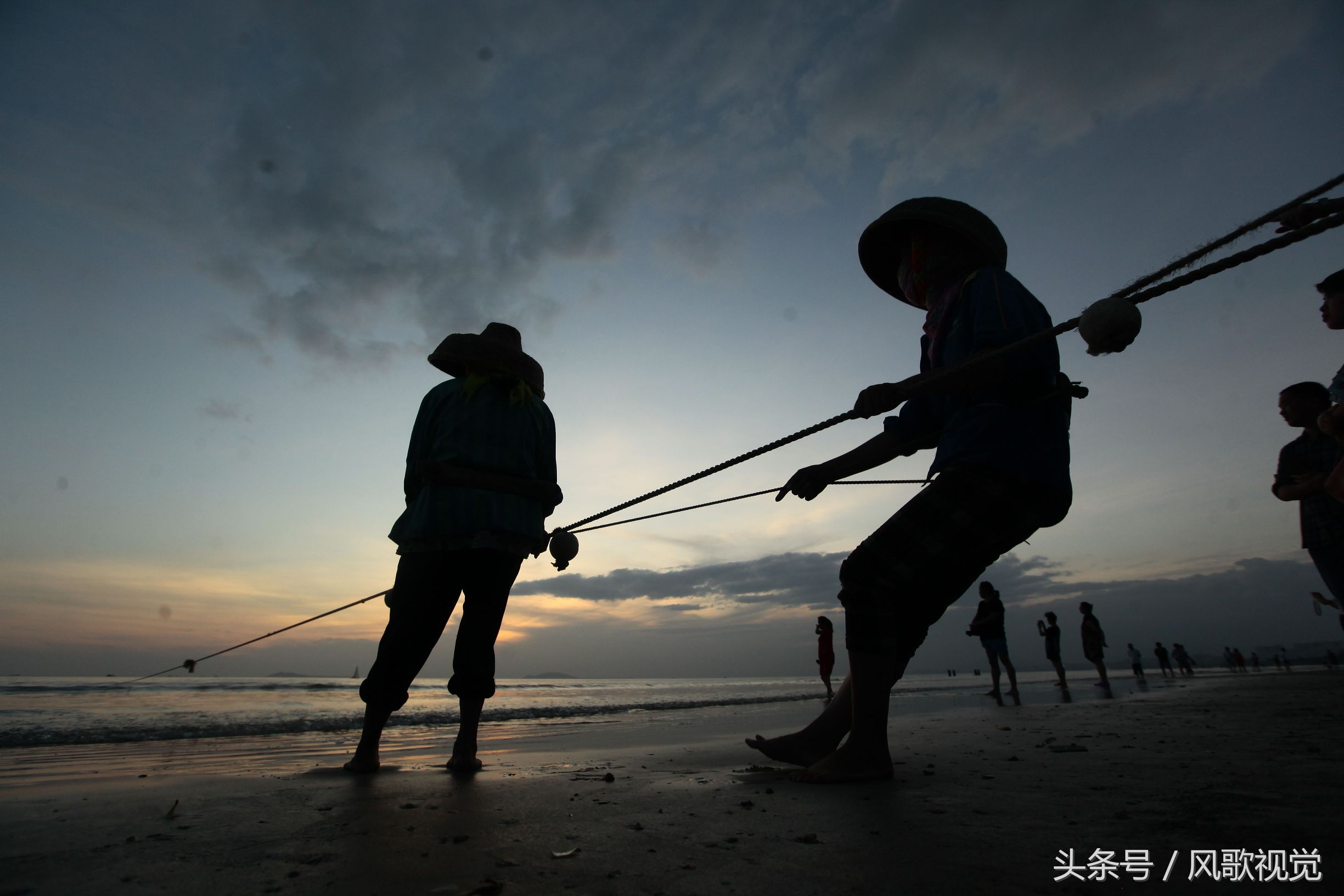 三亞灣的少數民族漁民拉網捕魚,傳統作業在夕陽餘暉中成美景