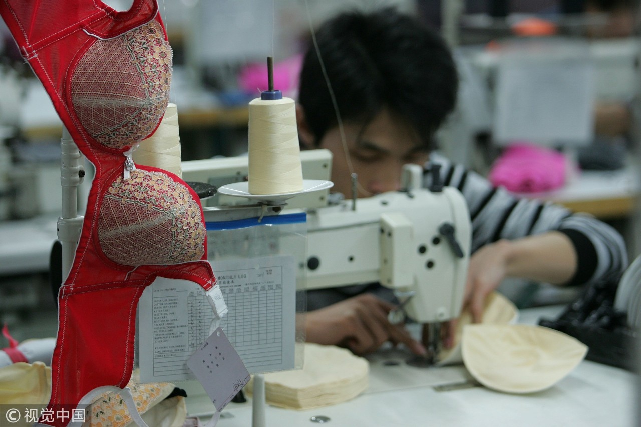 2011年2月28日,广东东莞一年轻男子在内衣厂工作/ 视觉中国