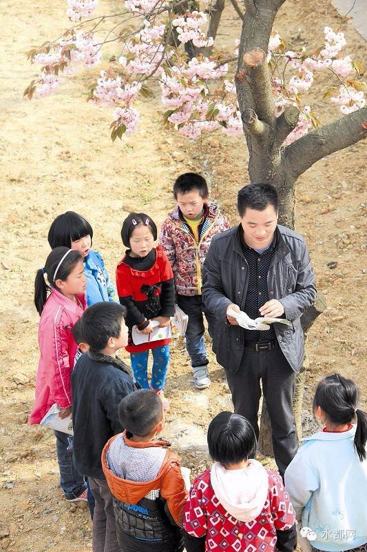 彭玉生在樱花树下为孩子们传授知识