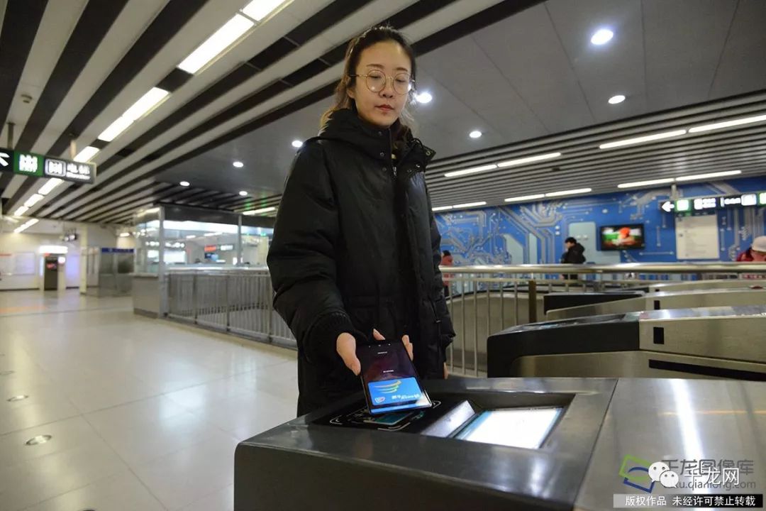 2月5日,乘客在北京地铁10号线体验手机互通卡进站乘车(图片来源:tuku.