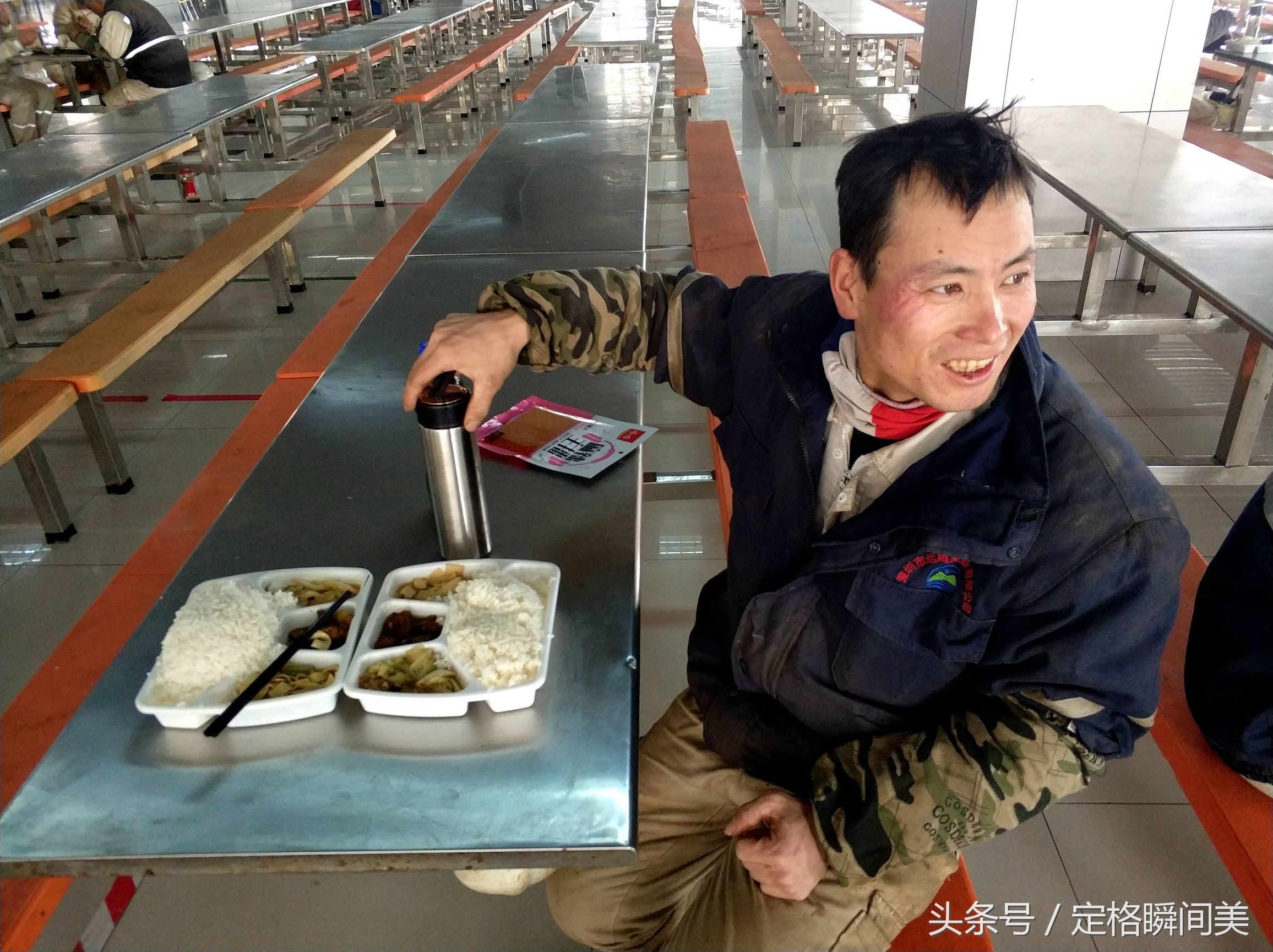 圖為:重工船廠企業裡,一名工人師傅在吃午餐盒飯.