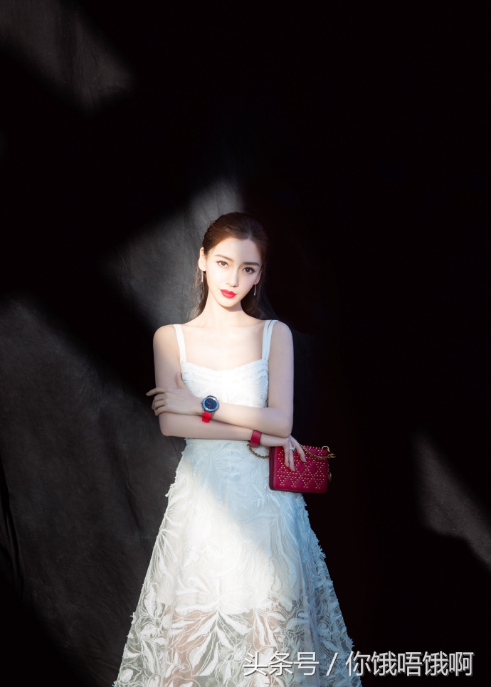 angelababy的工作室放出一组她穿上迪奥的白色纱裙,拿着最新款红色