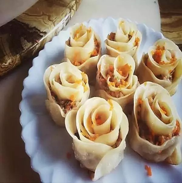 1玫瑰饺按上面波浪饺子的捏法捏出花边用手捏合三条边成为一个立体的