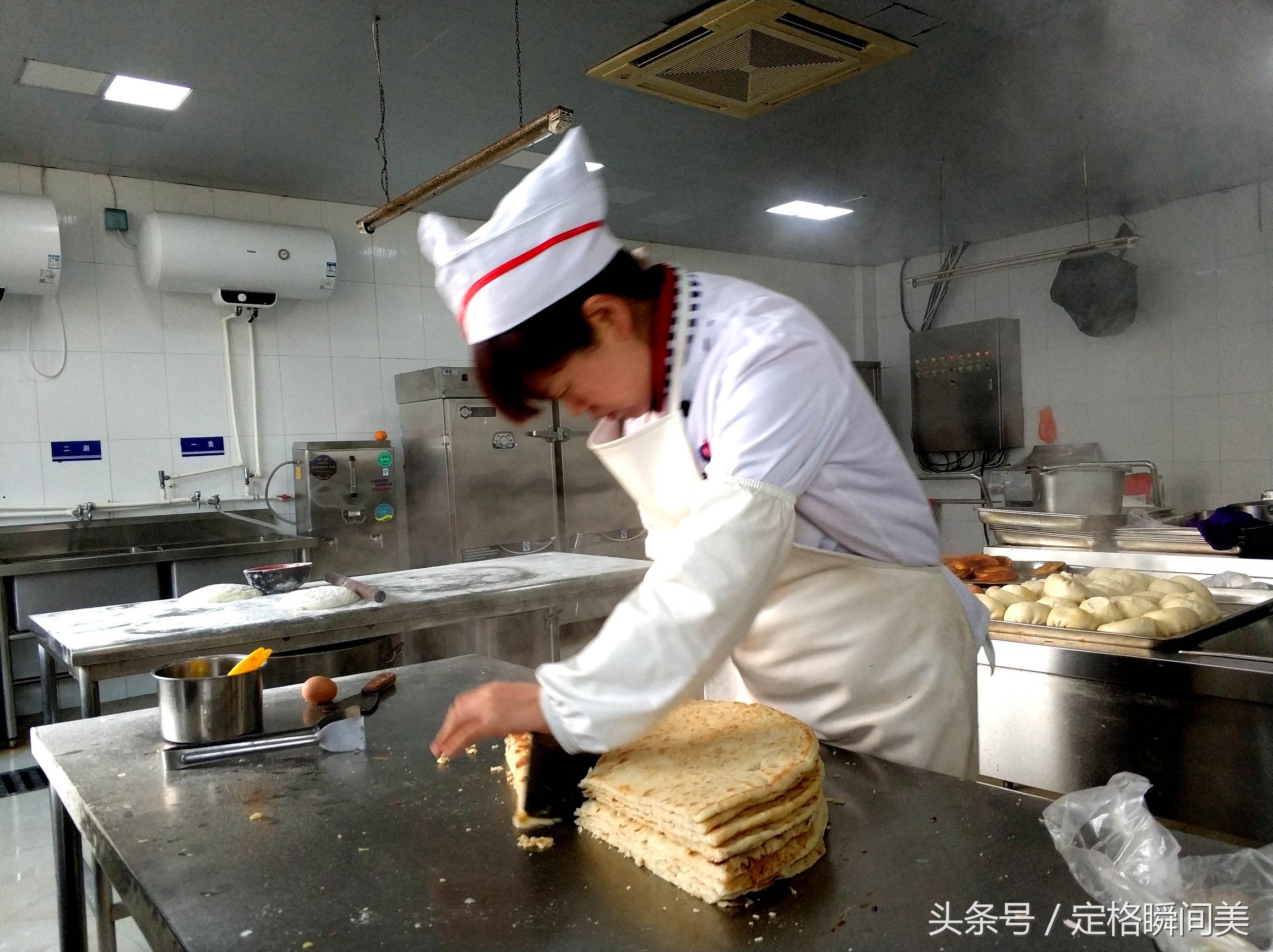 图为:食堂餐厅里,厨师阿姨将出锅的三角饼,分割成若干个出售.