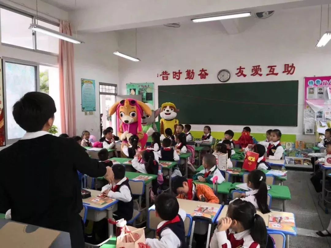 灵源街道华林小学开学典礼上,华林小学老师为学生分发"学习雷锋 乐于