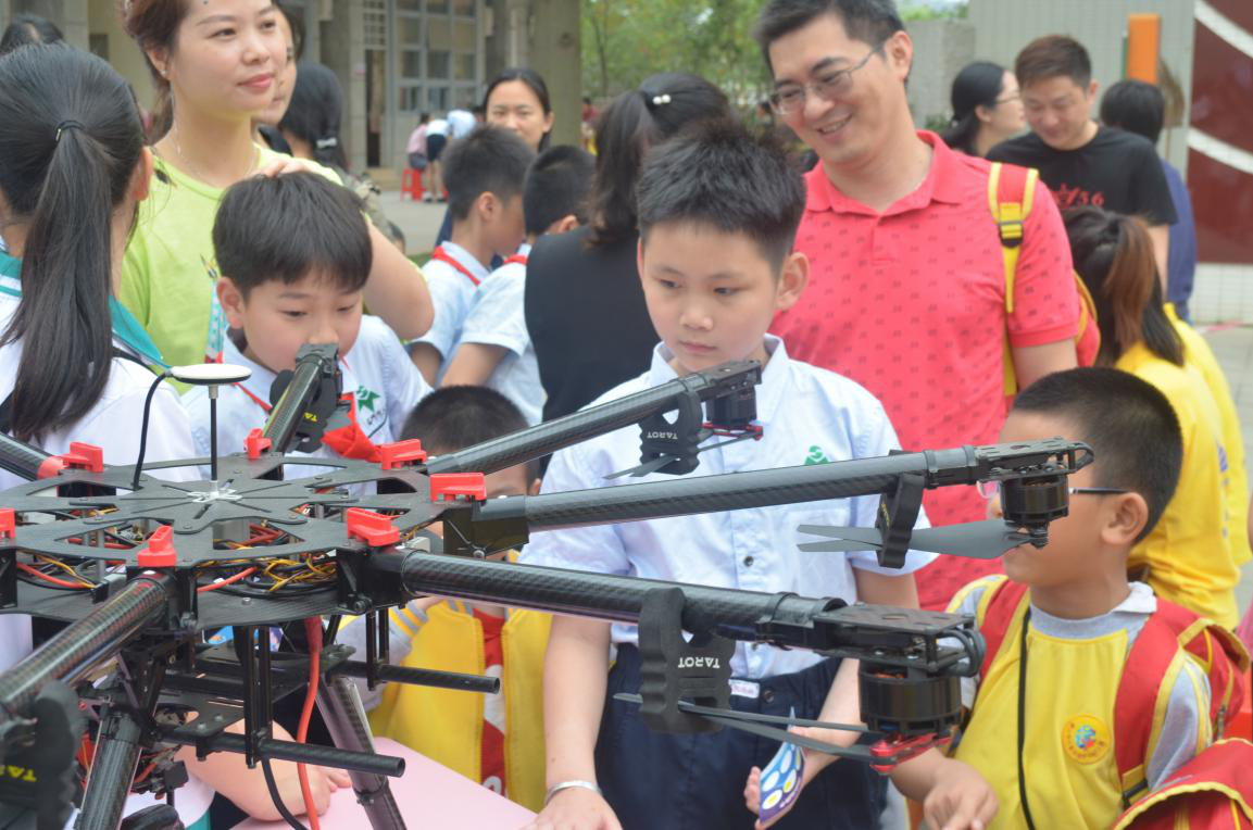 体验区挤满了学生和家长,现场除了展示出各种机型的无人机,航模外