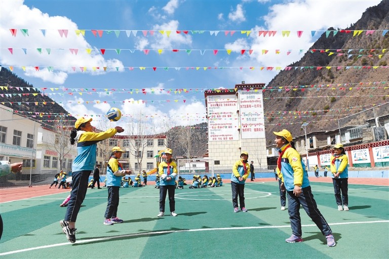 图为近日,昌都市边坝县尼木乡希望小学学生正在体育课上练习排球.