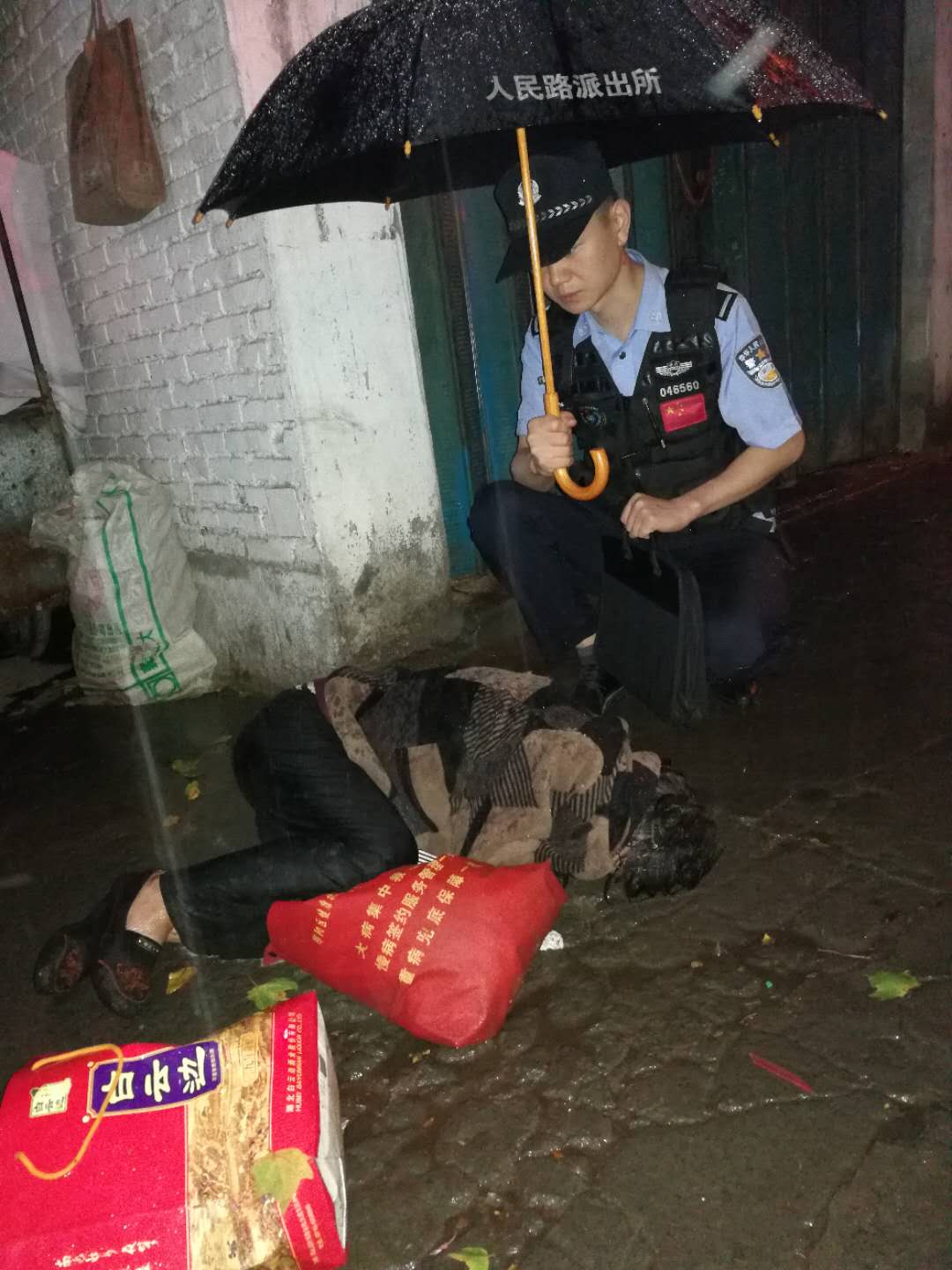 流浪女凌晨醉酒卧地昏迷 民警雨中撑伞救助