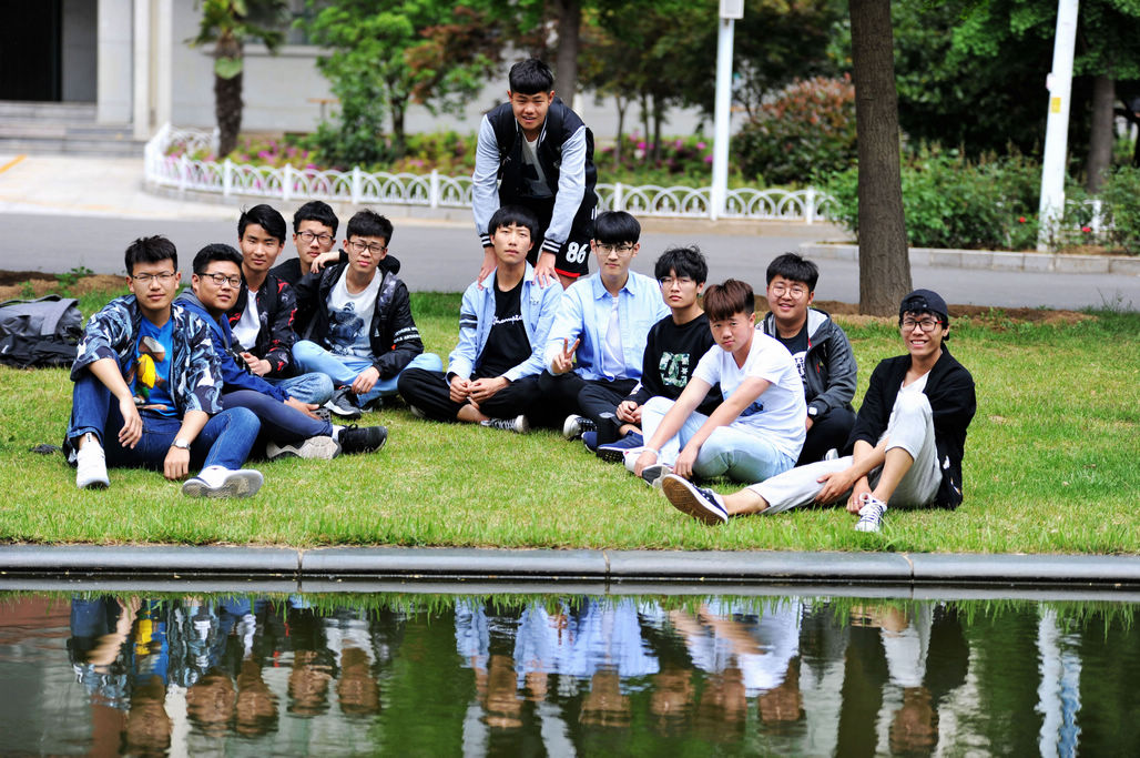 5月7日,山东科技大学校园,大学生们在墨水河畔草地上小憩.