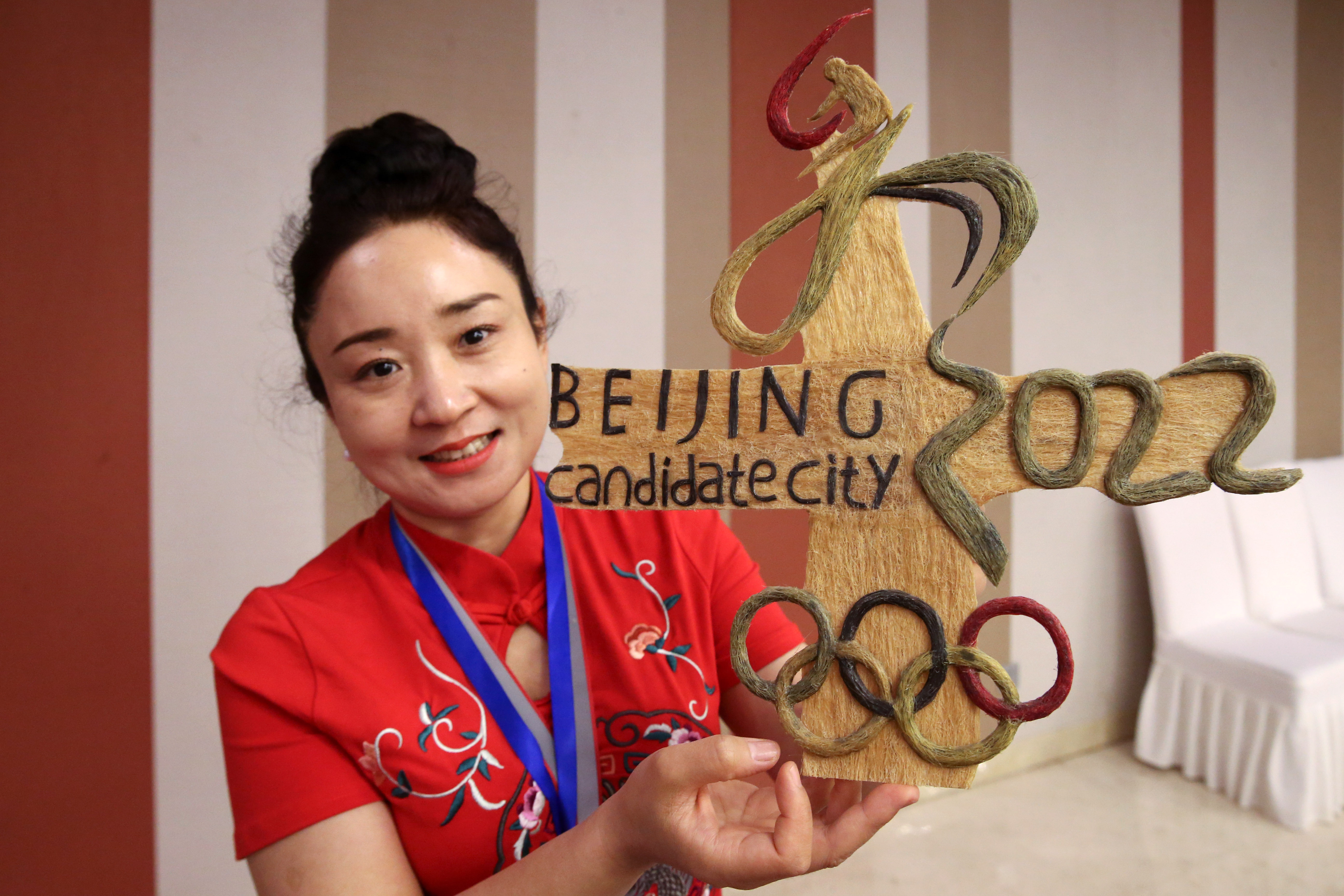 2018年5月9日,工作人员在发布会现场展示发雕版北京冬奥会会徽