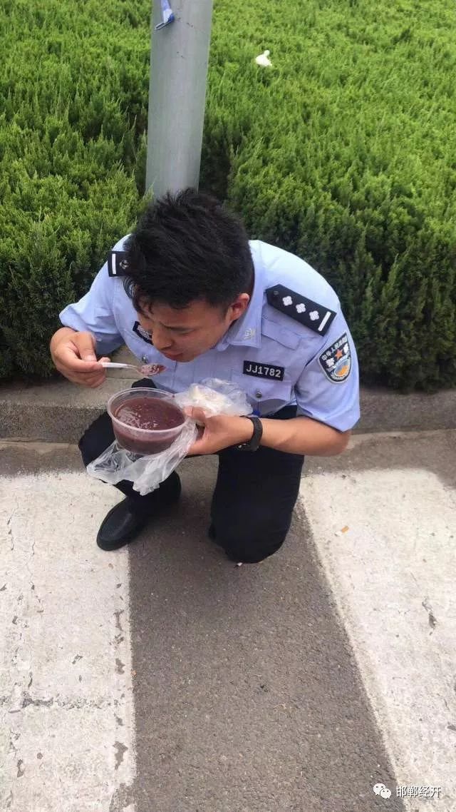 民警在考生开考后,蹲在地上吃饭.