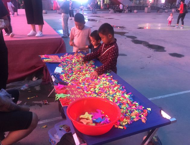 小周哥看见孩子最多的小摊就是泡水玩具摊夜幕降临时,在富瑞特广场的