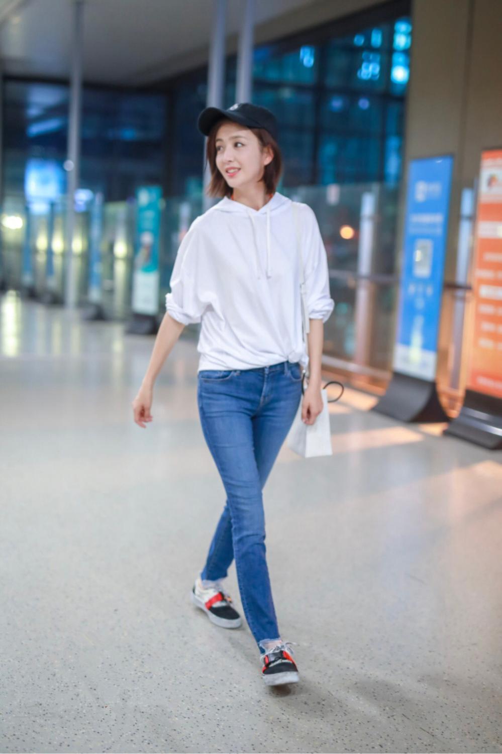 佟丽娅穿白色卫衣搭配牛仔裤现身机场 清纯可人笑容灿烂露梨涡