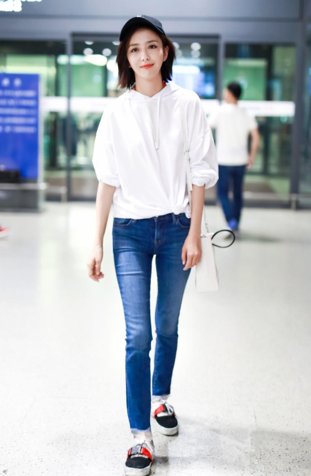 佟丽娅穿白色卫衣搭配牛仔裤现身机场 清纯可人笑容灿烂露梨涡