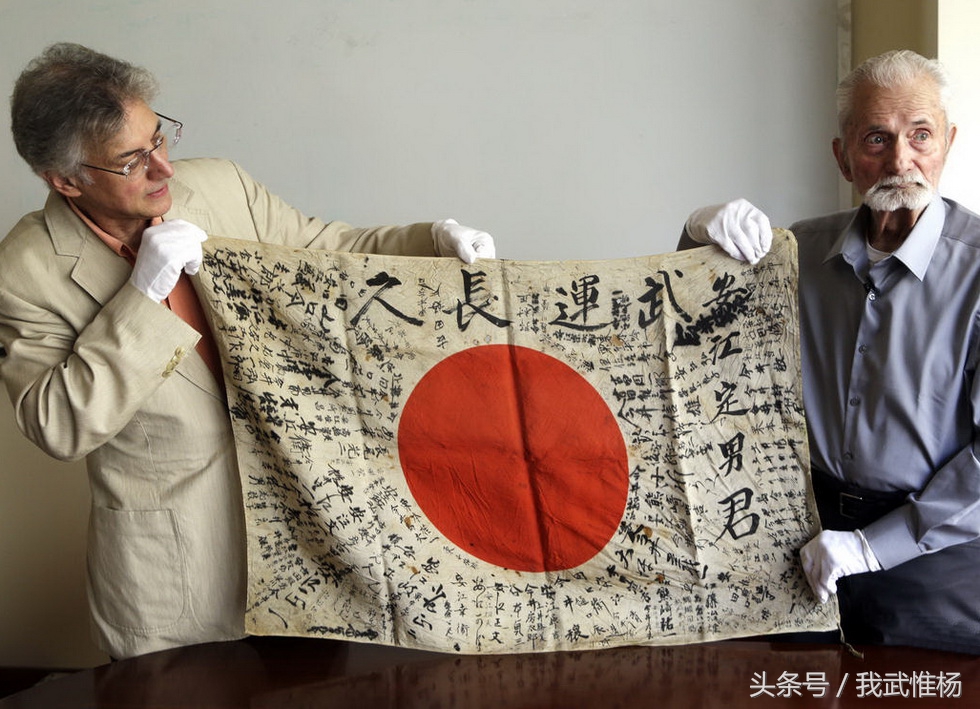 签名  斯特伦博手中的照片,是他当年在塞班岛战役时缴获日本国旗和