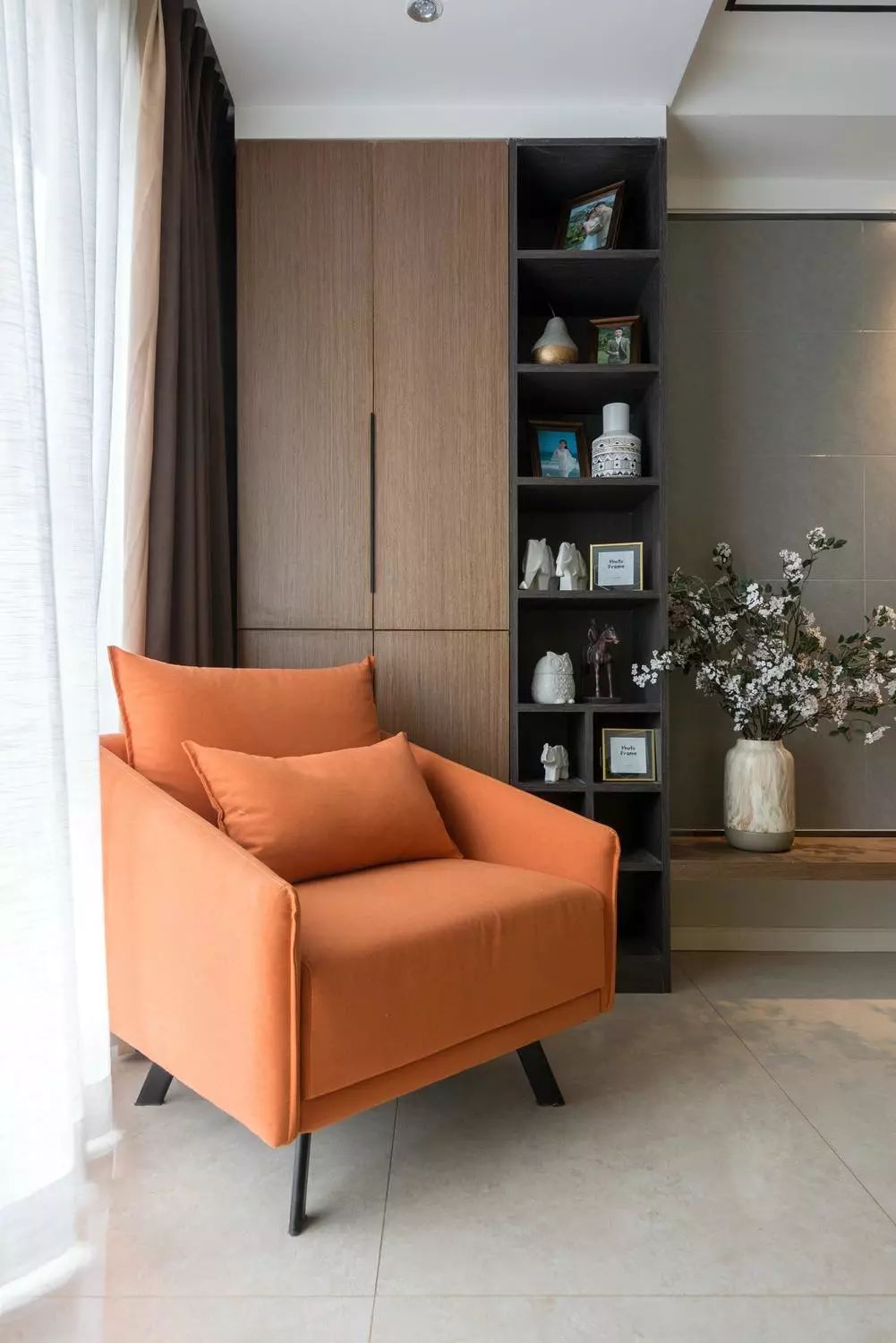 将阳台纳入客厅区域,木作装饰柜搭配橘色单人沙发,打造阳光休闲一角