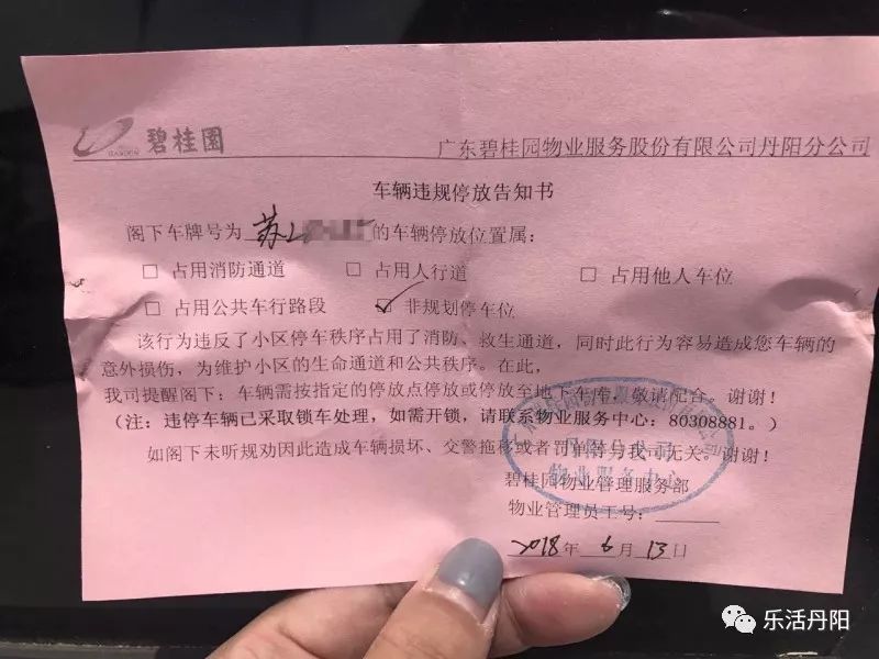 公共区域,出来的时候车子被锁住了,车上放了一张"车辆违规停放告知书"