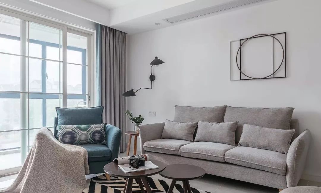 客厅采用灰蓝色家具,搭配蓝灰拼接窗帘,整体色调保持一致性
