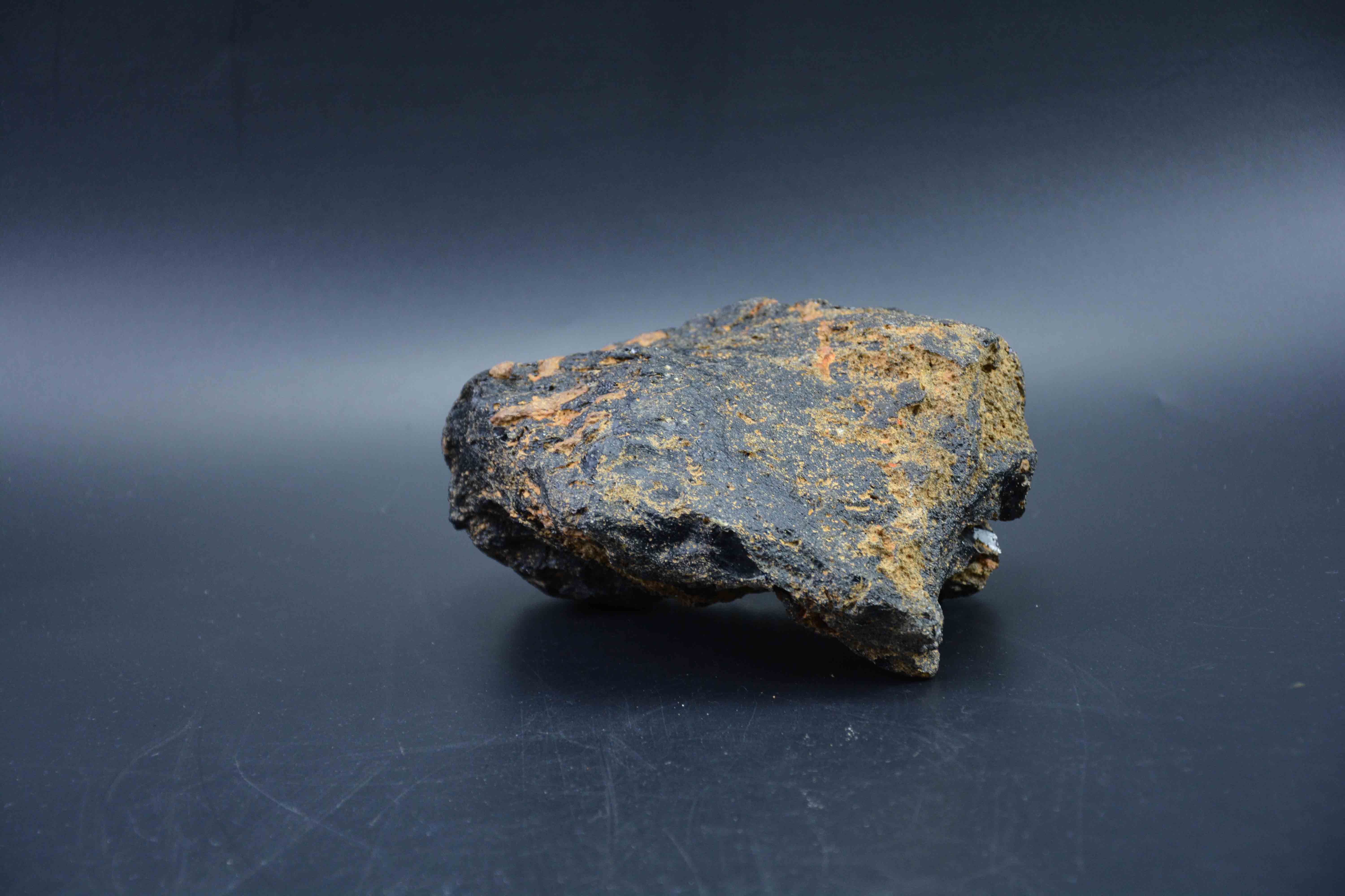 玻璃陨石整体呈现墨黑色,不规则形状,灼烧痕迹明显,气印密集漂亮,熔壳