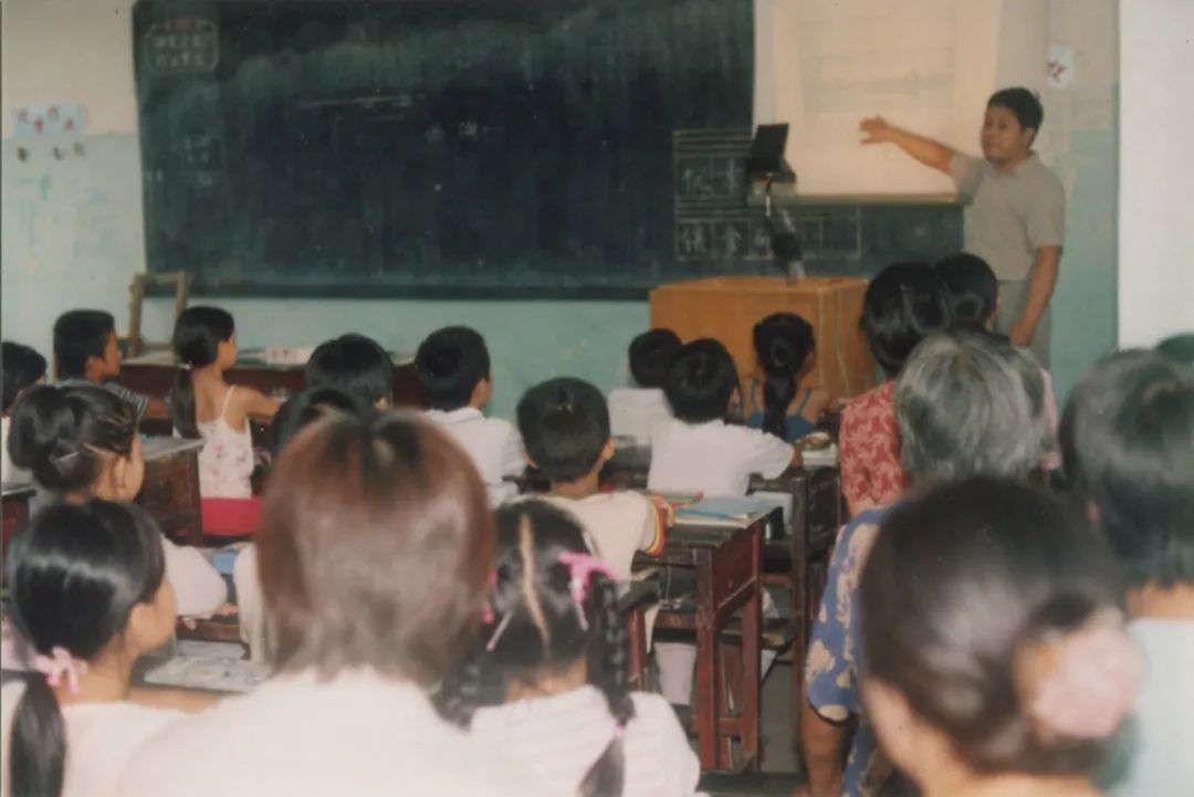 在教室上课的老师和学生90年代全体教职工合影大楼前的小学毕业照(摄