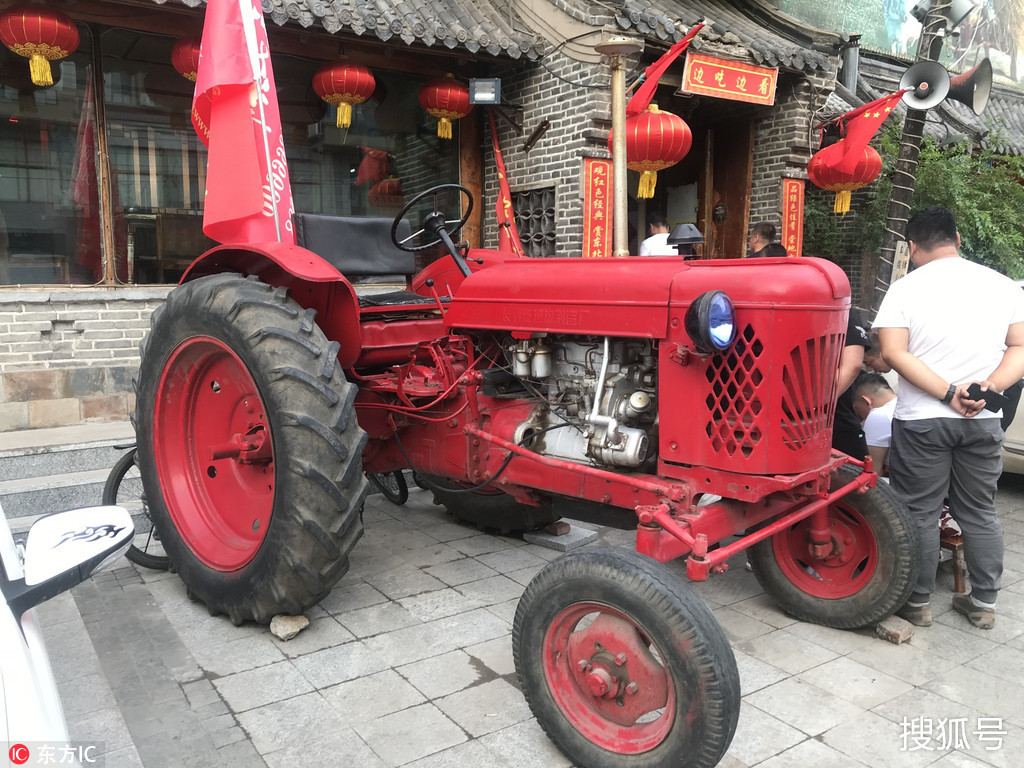 吉林长春岳阳街某大型饭店门口,停车场上停着一辆老式的东方红拖拉机