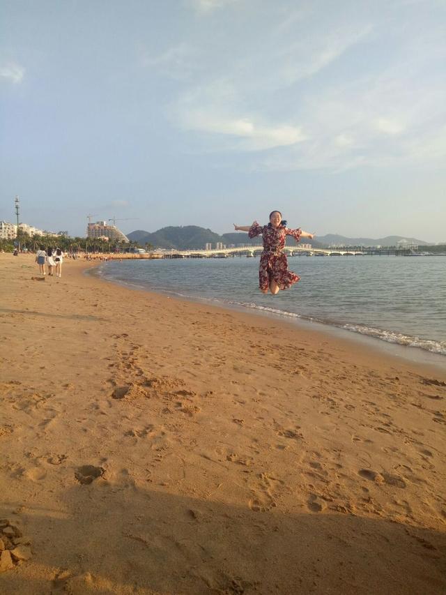 海上日落中踏浪闲行!海上落日,给大海染上了一层金色!