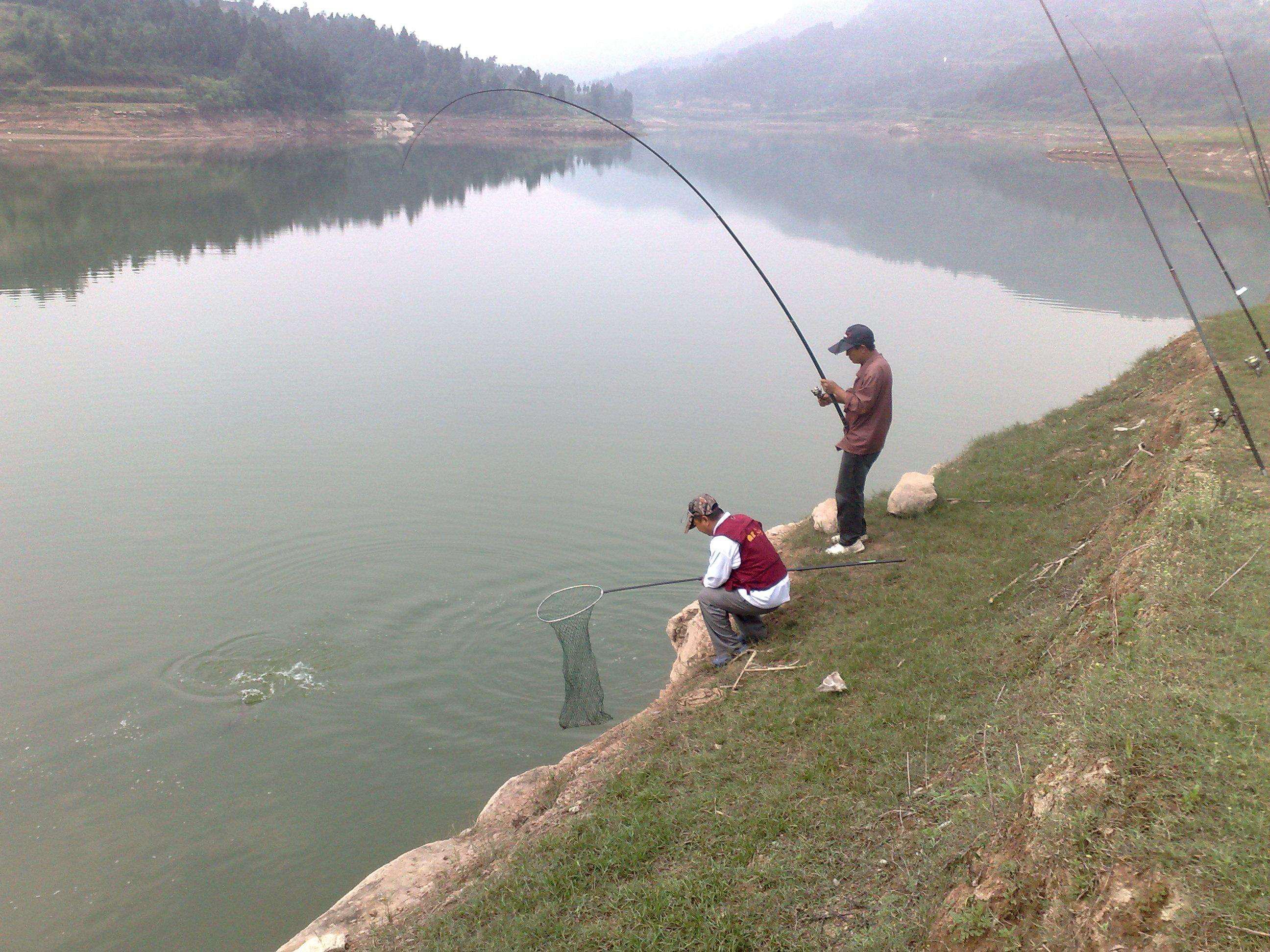 在乡村河边垂钓游玩的游客高清摄影大图-千库网