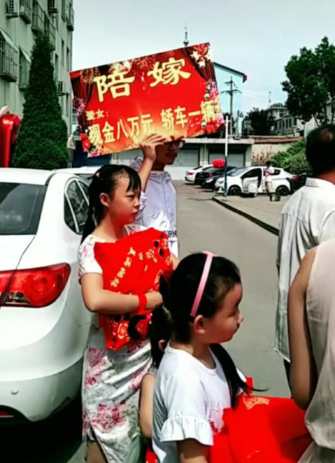 這是結婚現場,男方的婚車到女方家迎親,女方家裡舉著的陪嫁牌子.