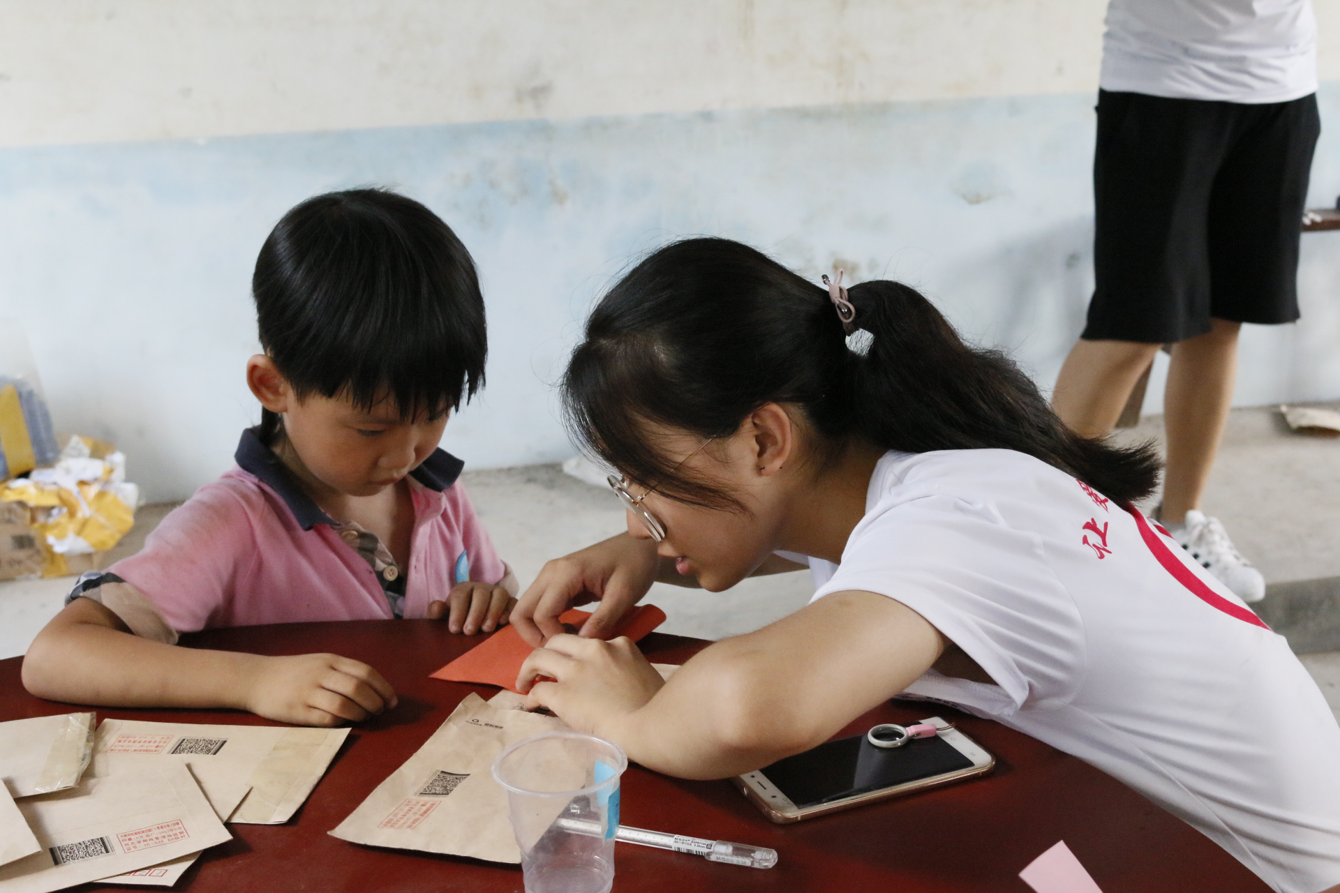 支教志愿者正在教孩子们折纸(图/胡海涛 摄)与你们初次的玩耍哥哥,你