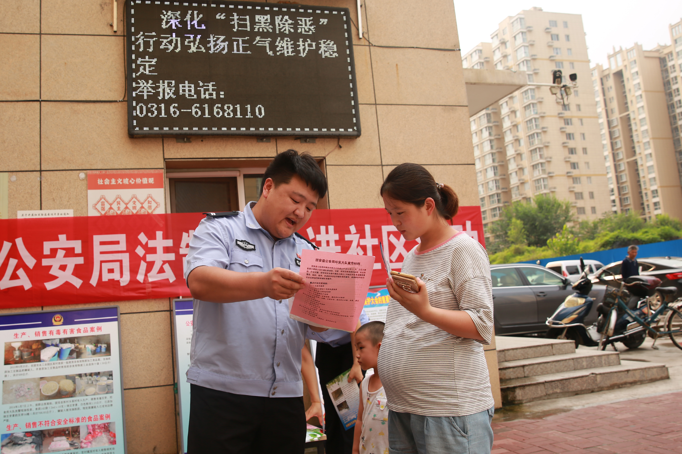 图为7月19日,民警在浩庭花园小区进行普法宣传