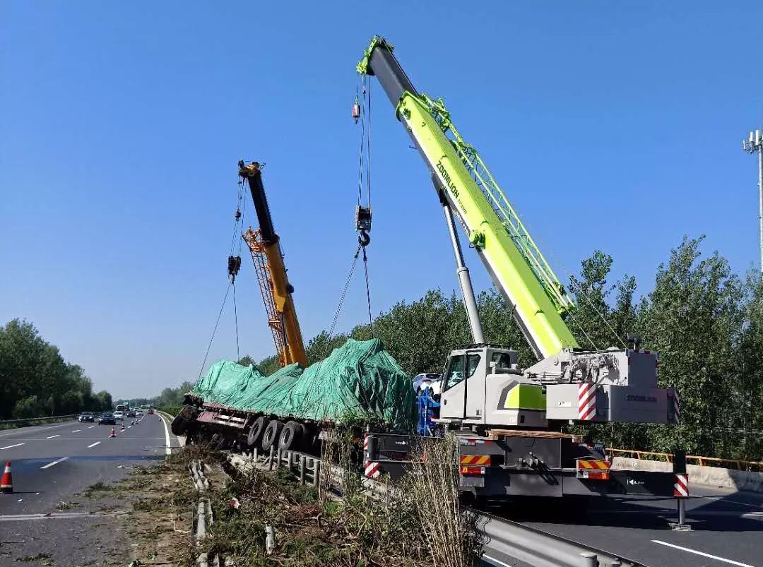 在事故發地點只見一輛滿載的重型半掛貨車整個騎壓在中心護欄上.