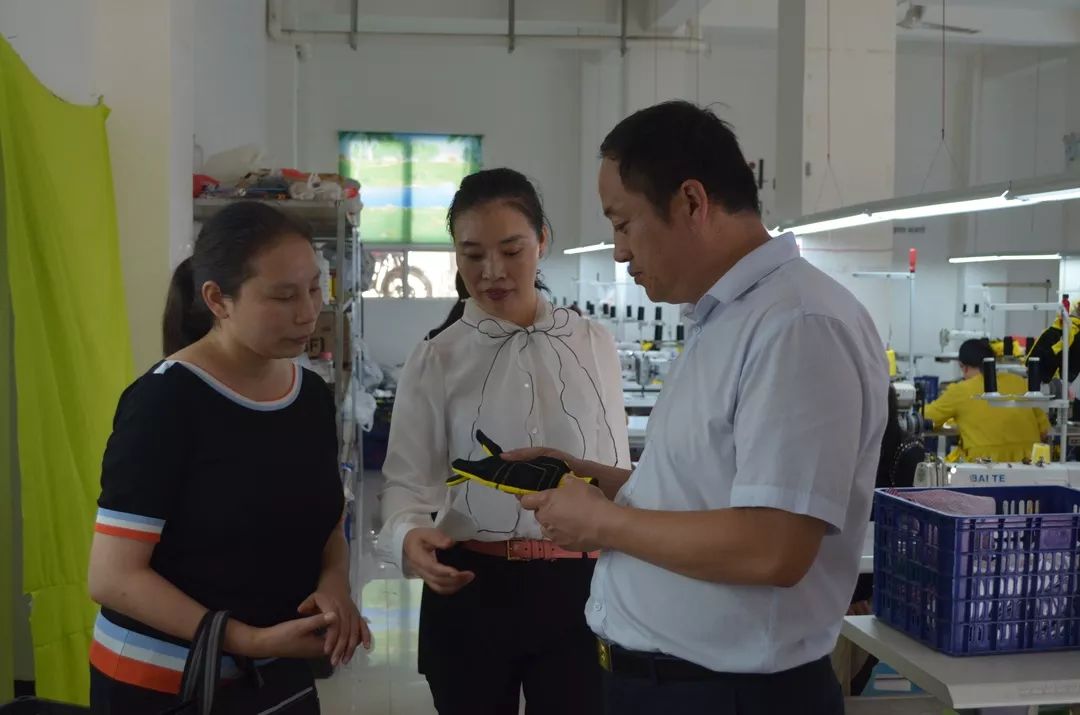 省妇联妇女发展部处级调研员谯治赟查看荣兴制衣厂产品荣兴制衣厂员工