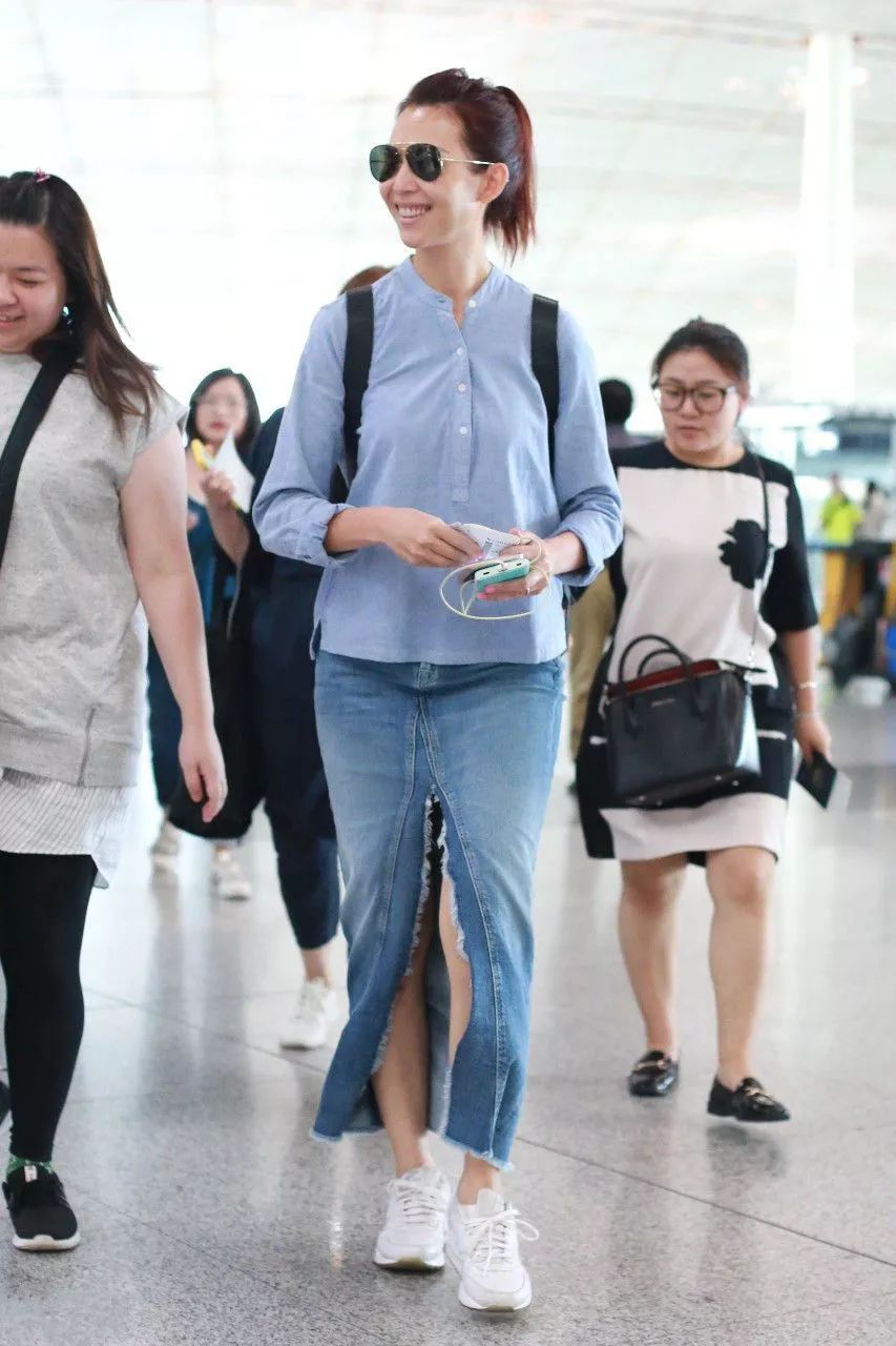 蔡少芬机场里打扮,宛如少女,一条牛仔裤子搭配蓝色衬衫,颜色十分洋气