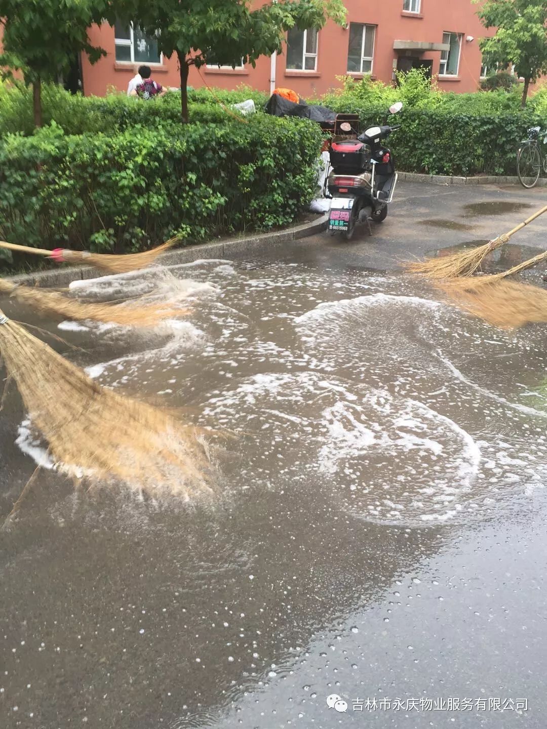 雨水过后,对小区积水的路面进行清理.