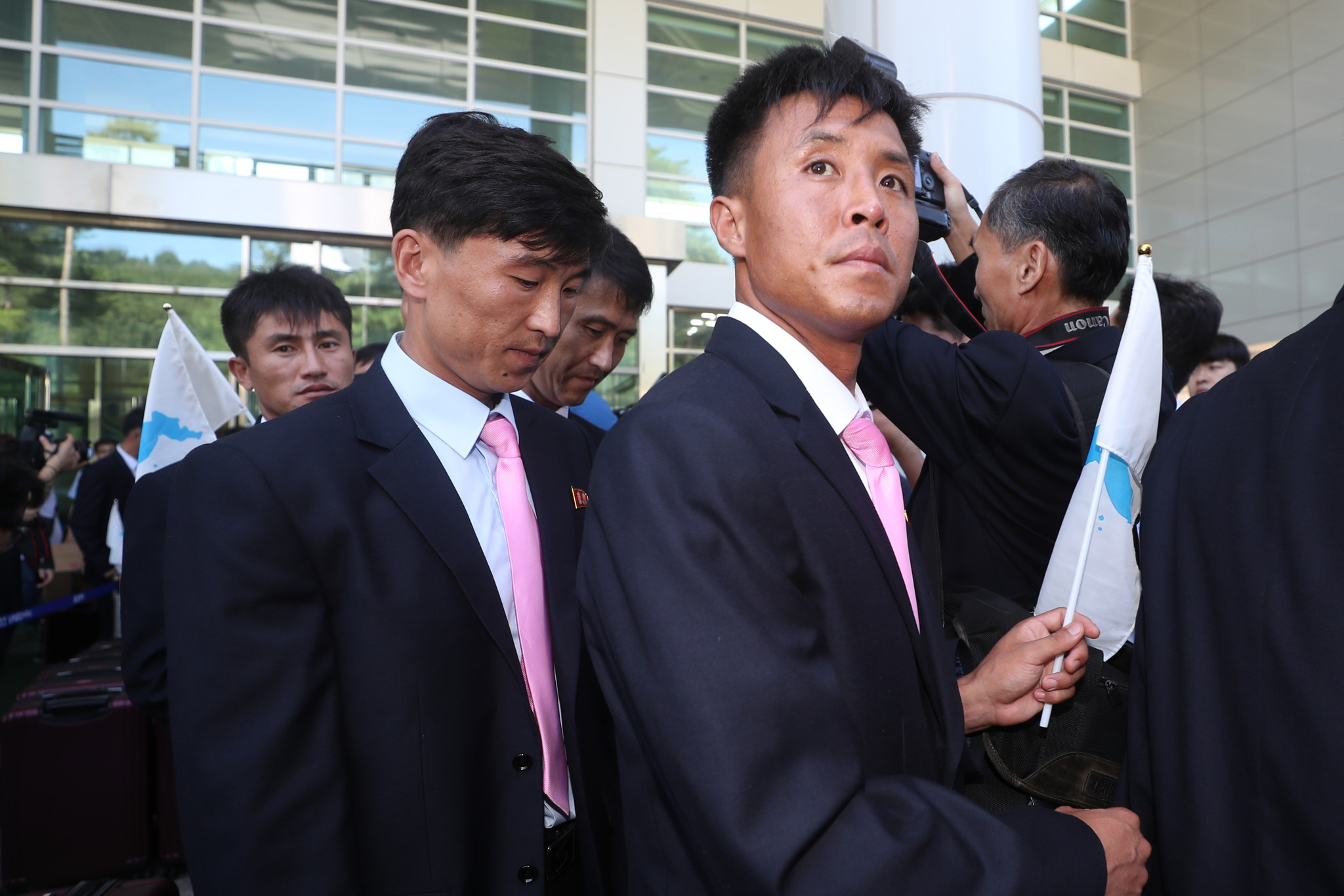 朝鲜部分运动员抵达韩国 手举半岛旗帜笑容朴实