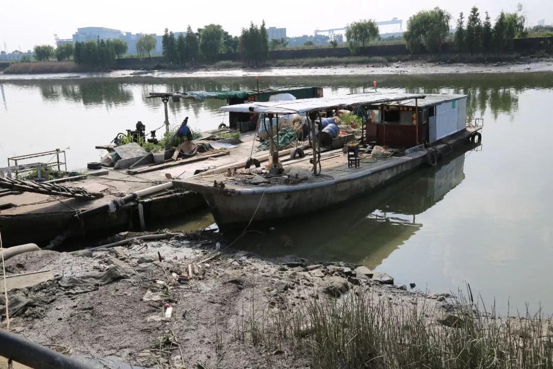 这里同样是臭气熏天,河边停靠这几艘捕捞红虫用的船只,占据了大半条道